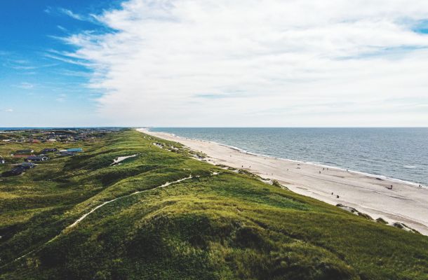 Eine Luftaufnahme eines Strandes und Sanddünen.