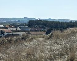 Eine Sanddüne mit Häusern darauf.