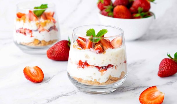 Zwei Glasdesserts mit Erdbeeren und Schlagsahne.