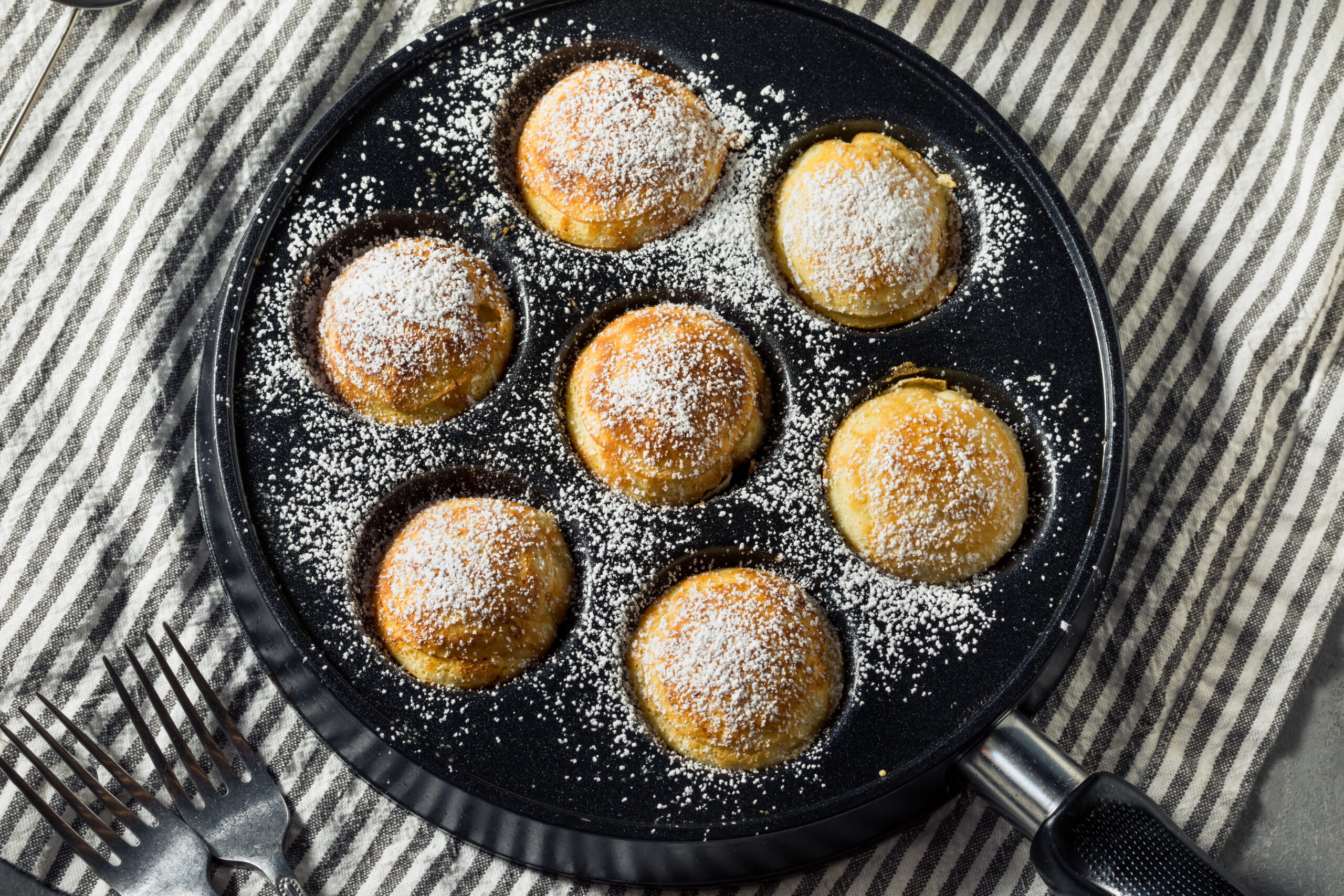 Pfannkuchen in einer Pfanne mit Puderzucker.