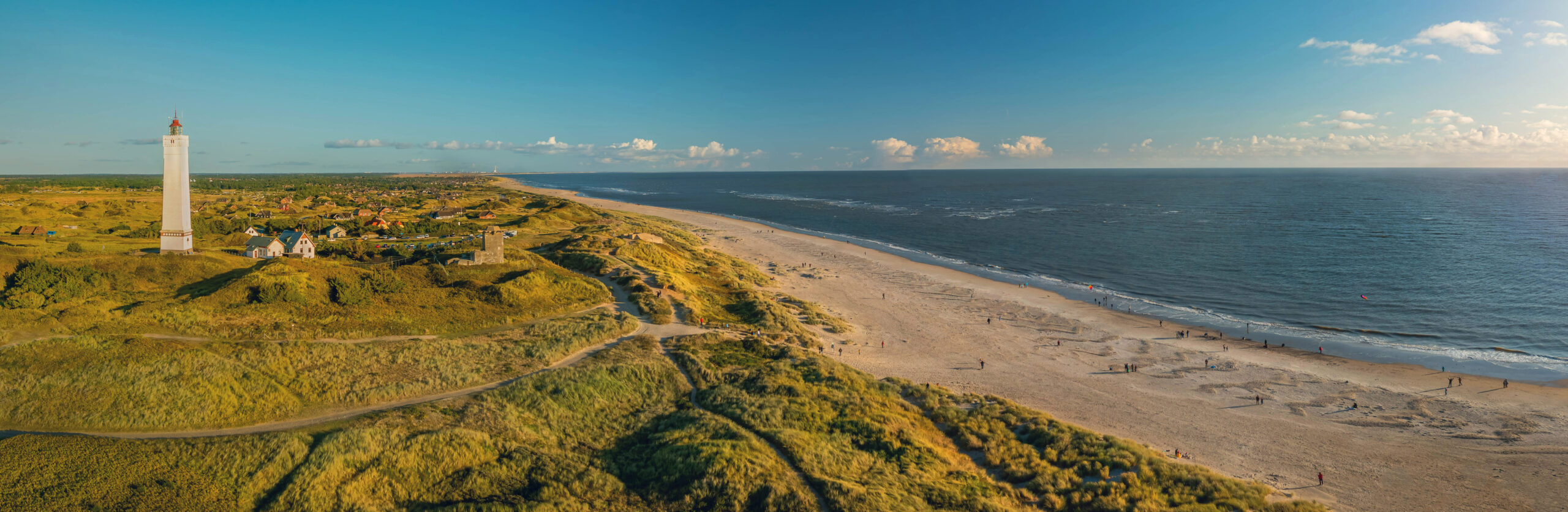 Eine Luftaufnahme eines Strandes mit einem Leuchtturm.